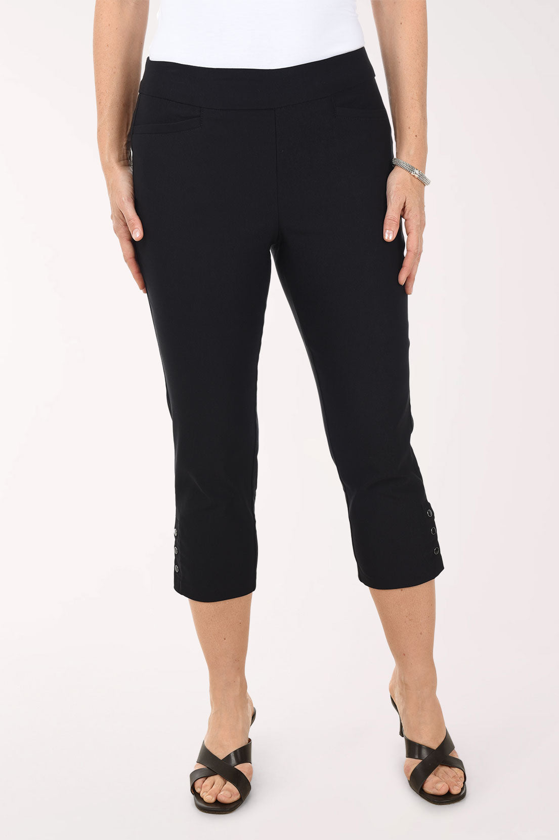 Person wearing black capri pants on a white background