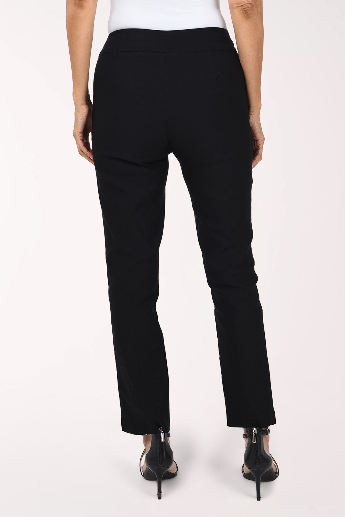 Back view of black straight leg pull-on ankle pants worn with black heels.