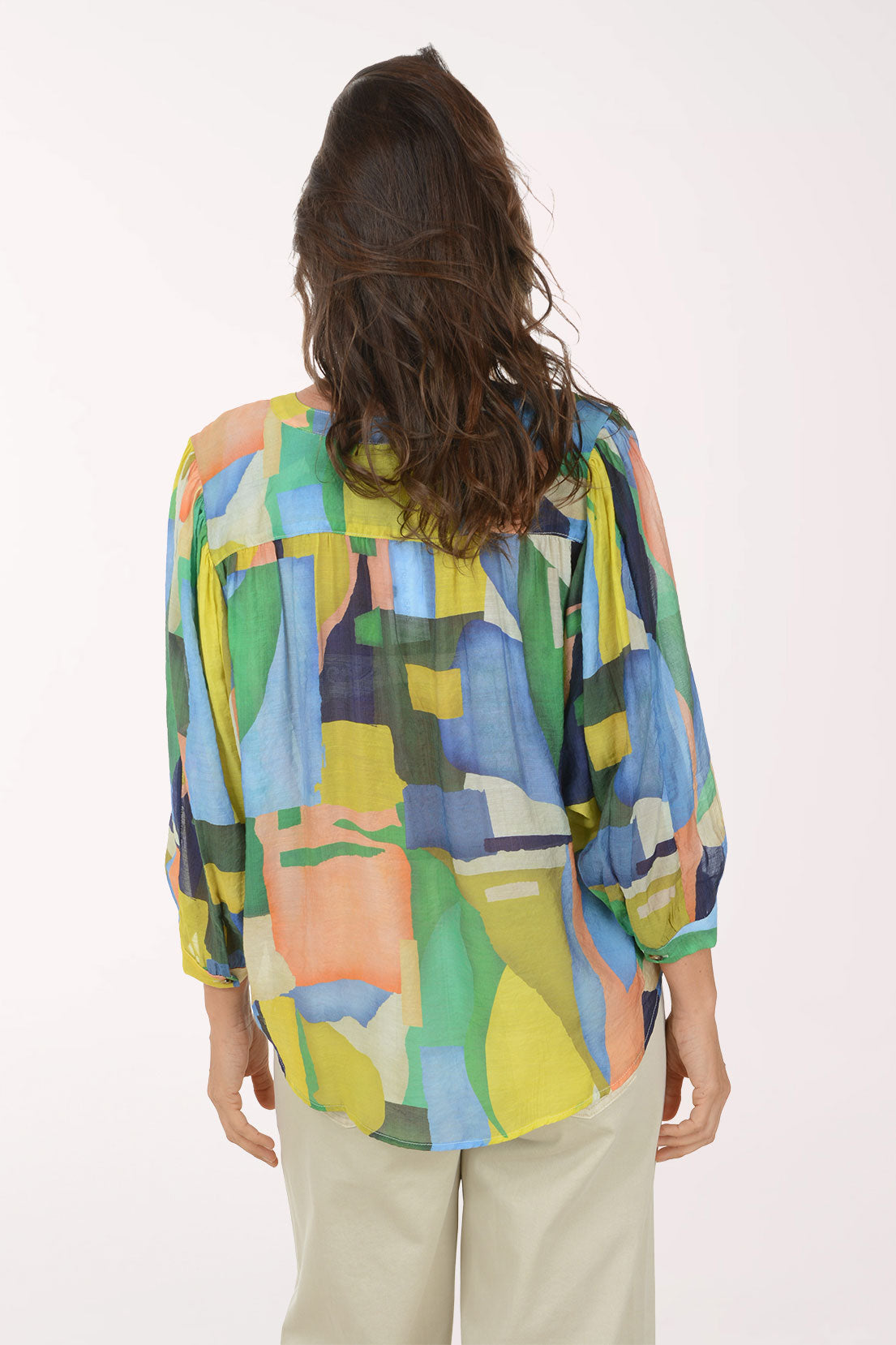 Woman wearing a colorful abstract patterned shirt on a white background