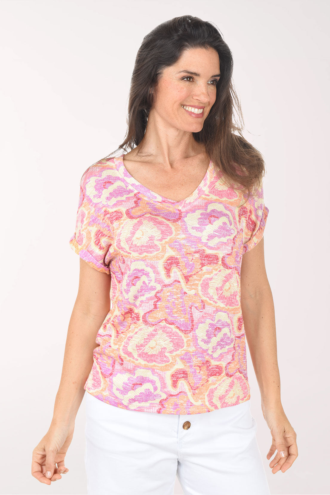 Woman wearing a pink and orange patterned top on a white background