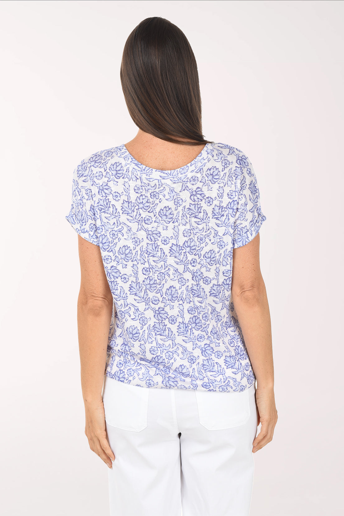 Woman wearing a blue floral patterned shirt on a white background