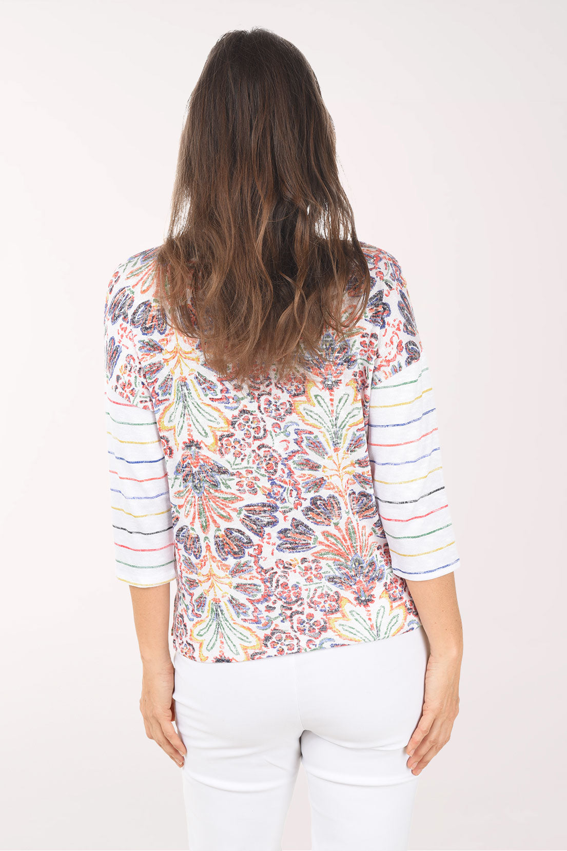 Woman wearing a colorful floral-patterned shirt on a white background