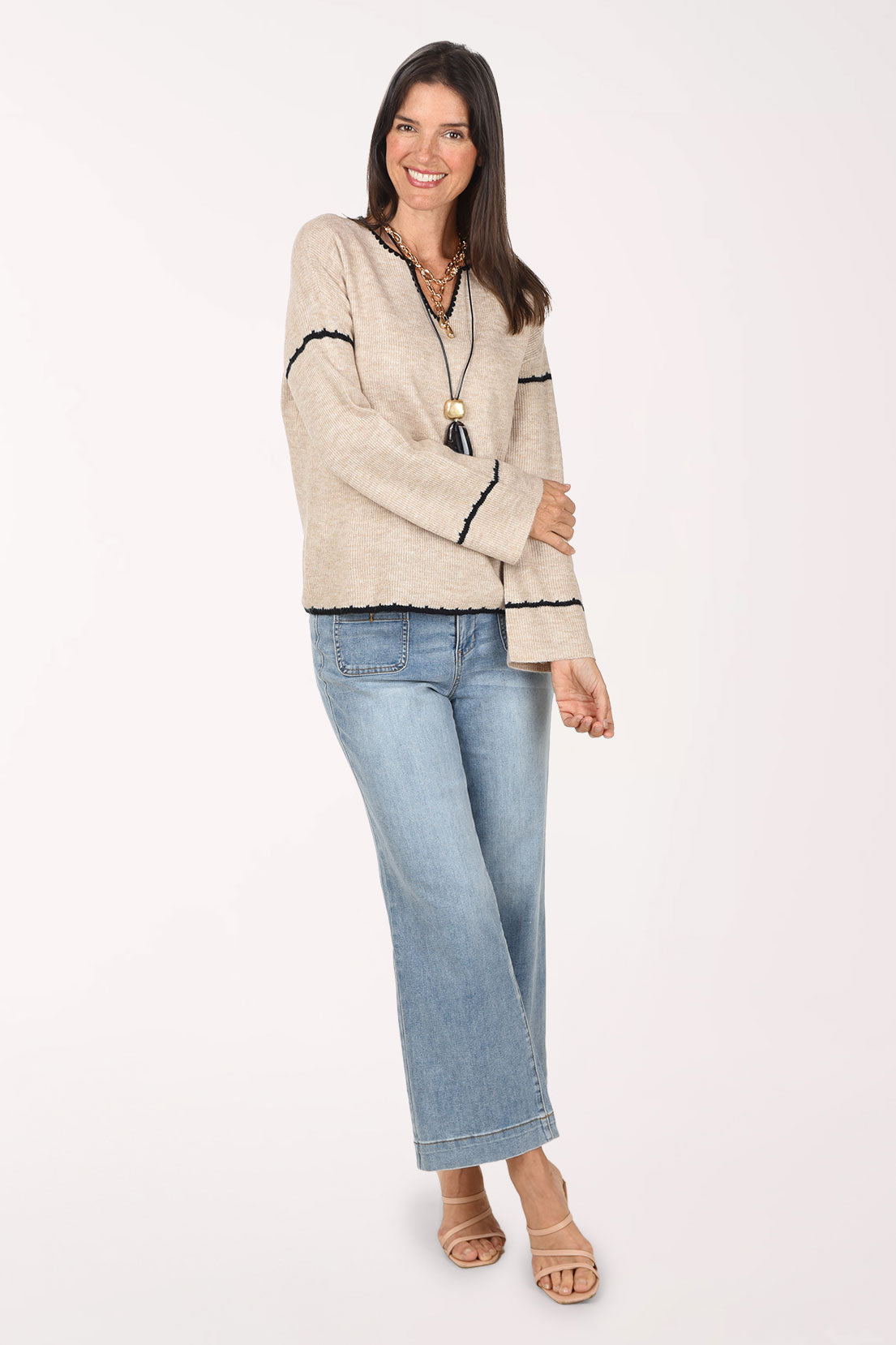 Full-length front view of the Super Straight Patch Pocket Denim Pant in Skylight light-wash denim, styled with an oatmeal sweater with black trim, a layered necklace and nude sandals.