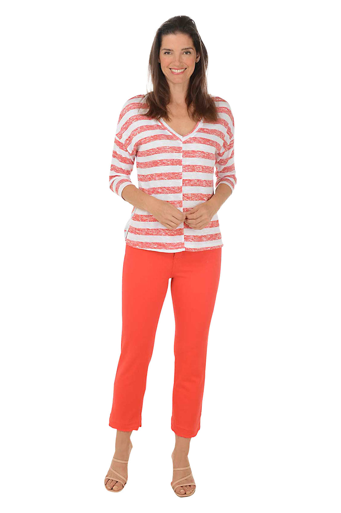 A full length shot of a model wearing a pair of red distressed hem denim ankle pants with a belt loop, zip fly and button closure, and micro flared leg.