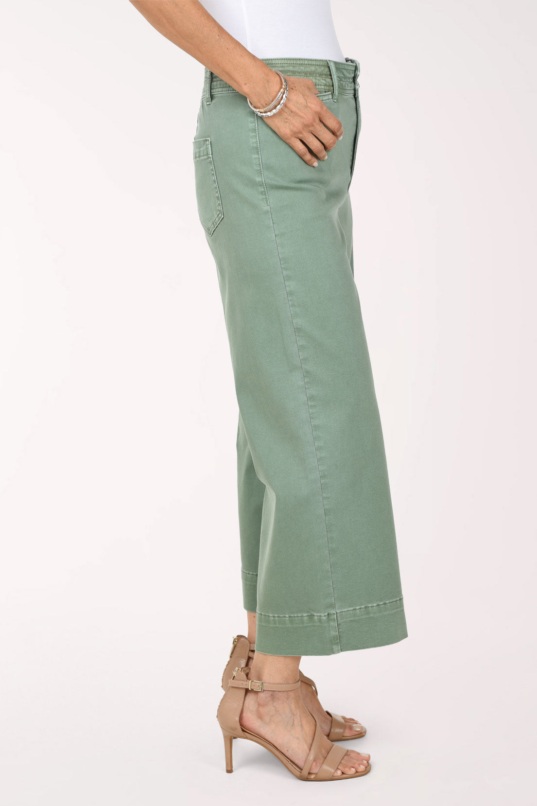 Side view of sage green Moss wide leg crop pants showing the front slit pocket and the straight wide leg falling to a cropped length above the ankle.