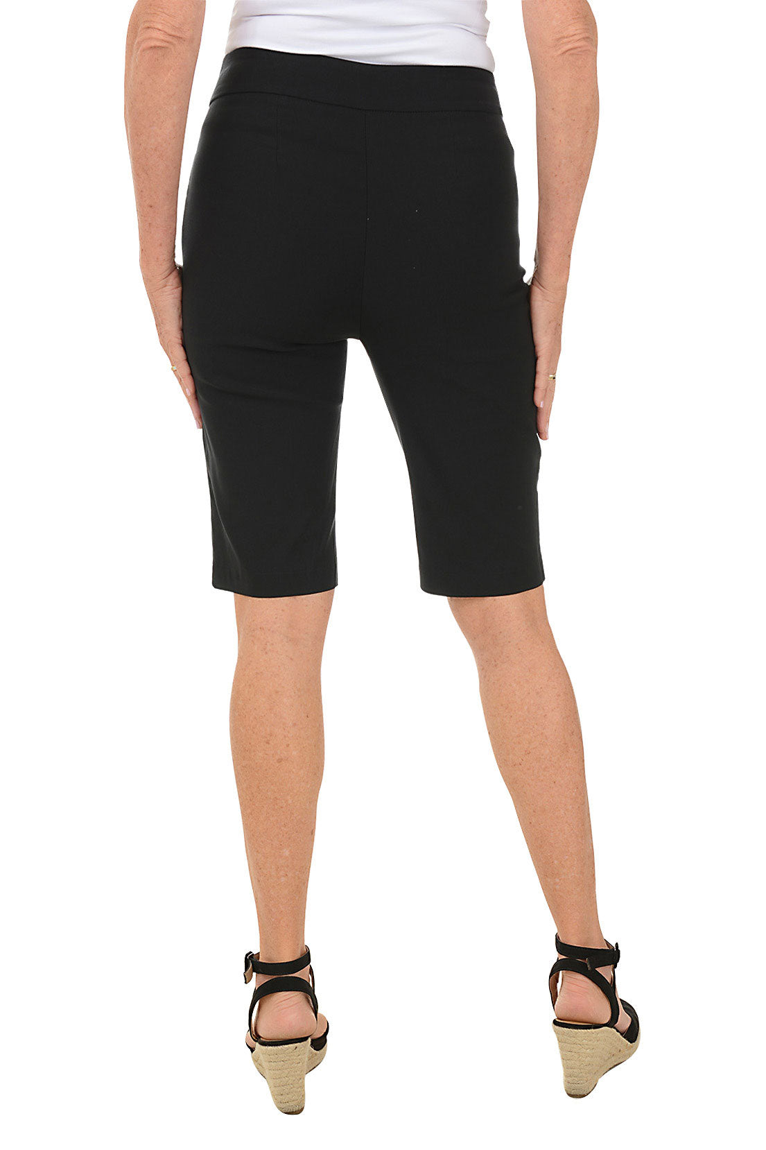 A model wearing black petite triple grommet hem bermuda shorts with elasticized waistband and dual front pockets. Back shot.