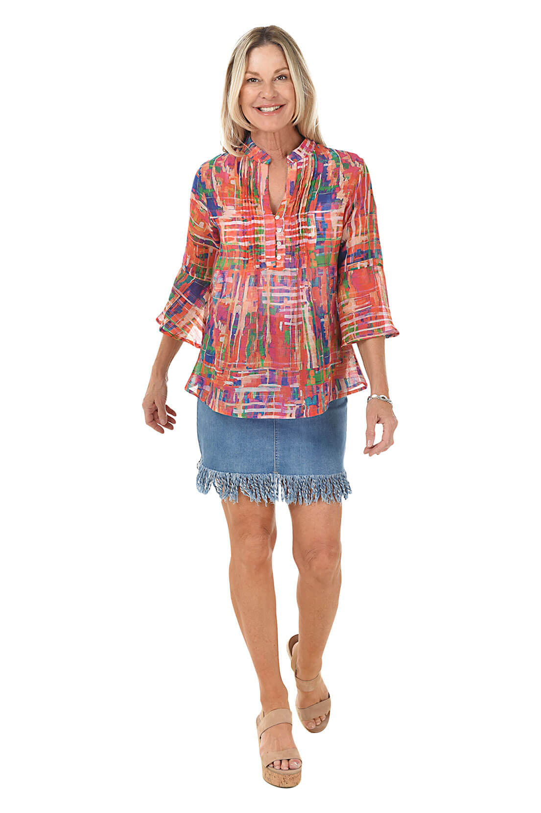 Woman wearing a colorful blouse and denim skirt on a white background
