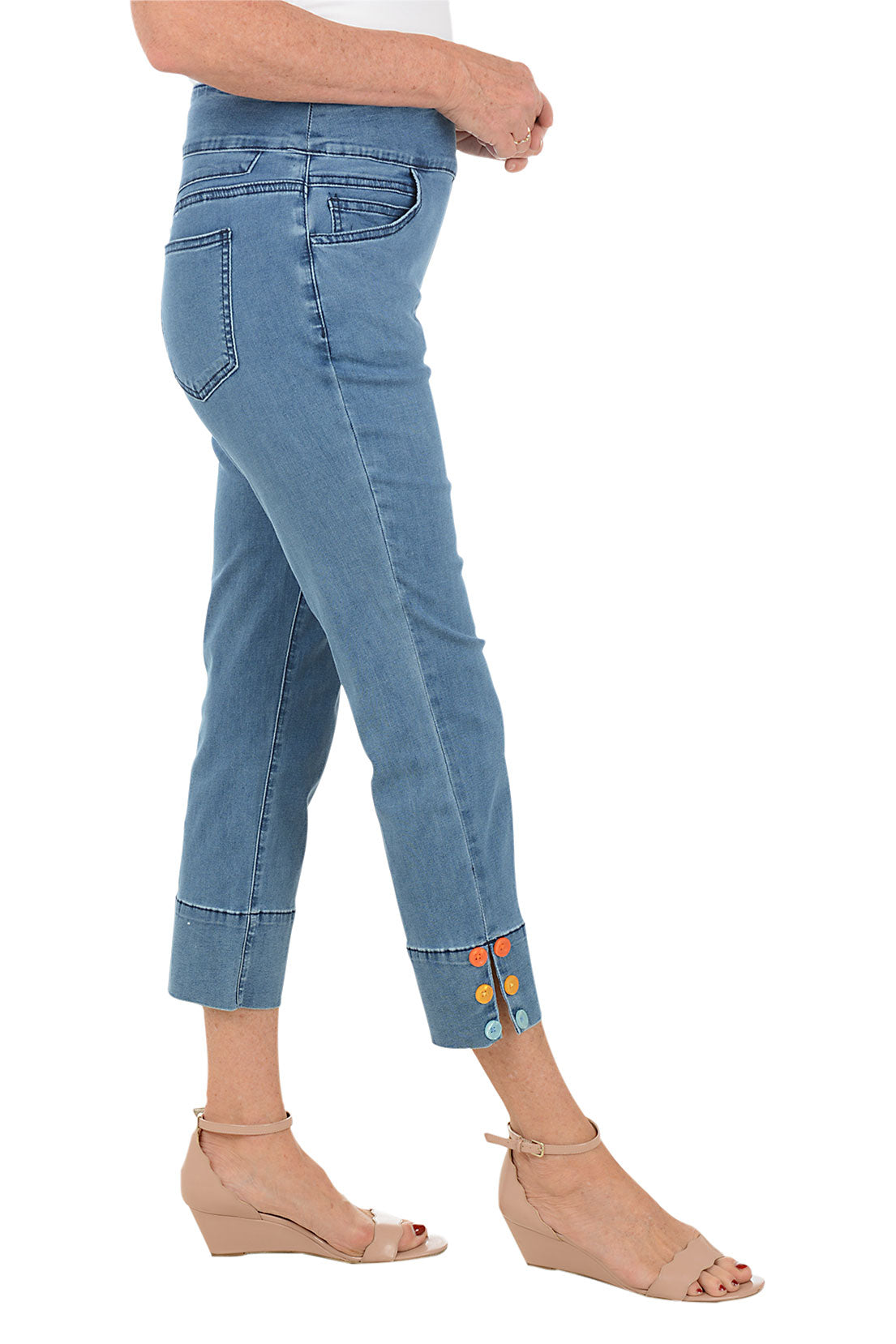 Blue jeans with colorful accents worn by a person on a white background. Side shot.
