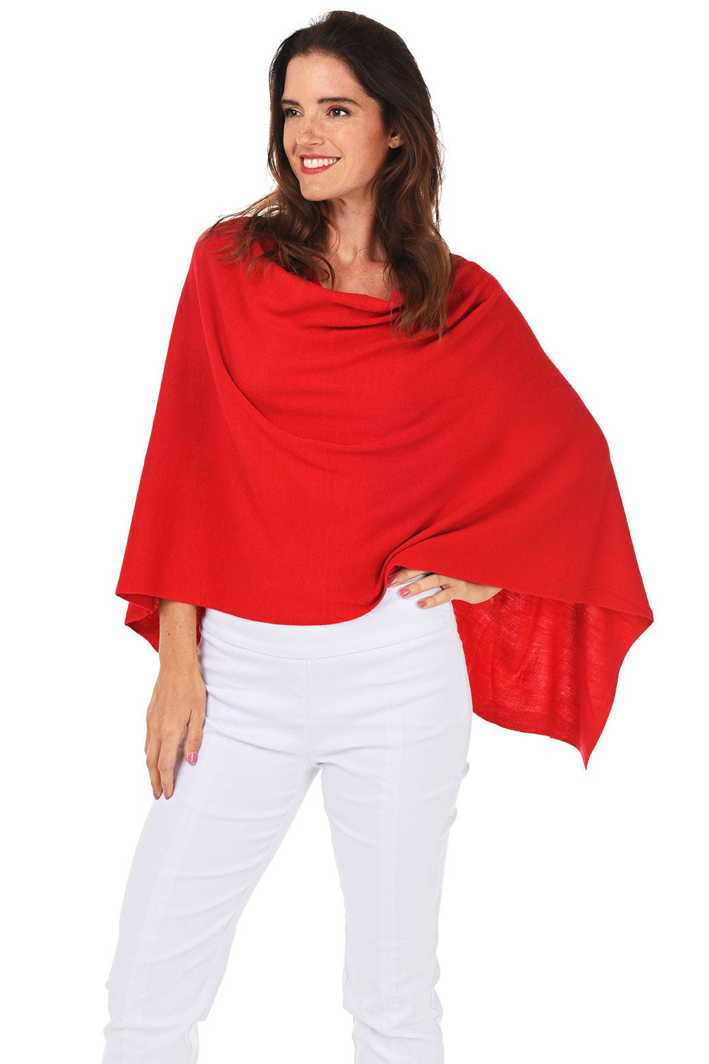 A woman wearing a red popover poncho with white pants.