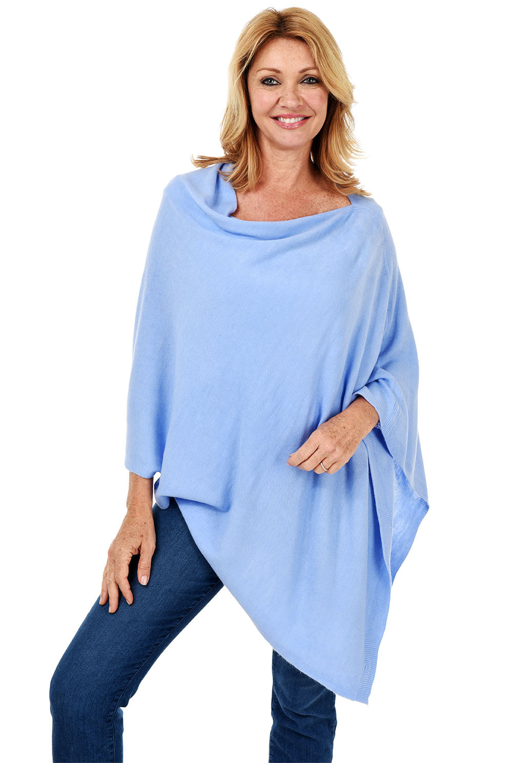 A woman wearing a lilac popover poncho with white pants.