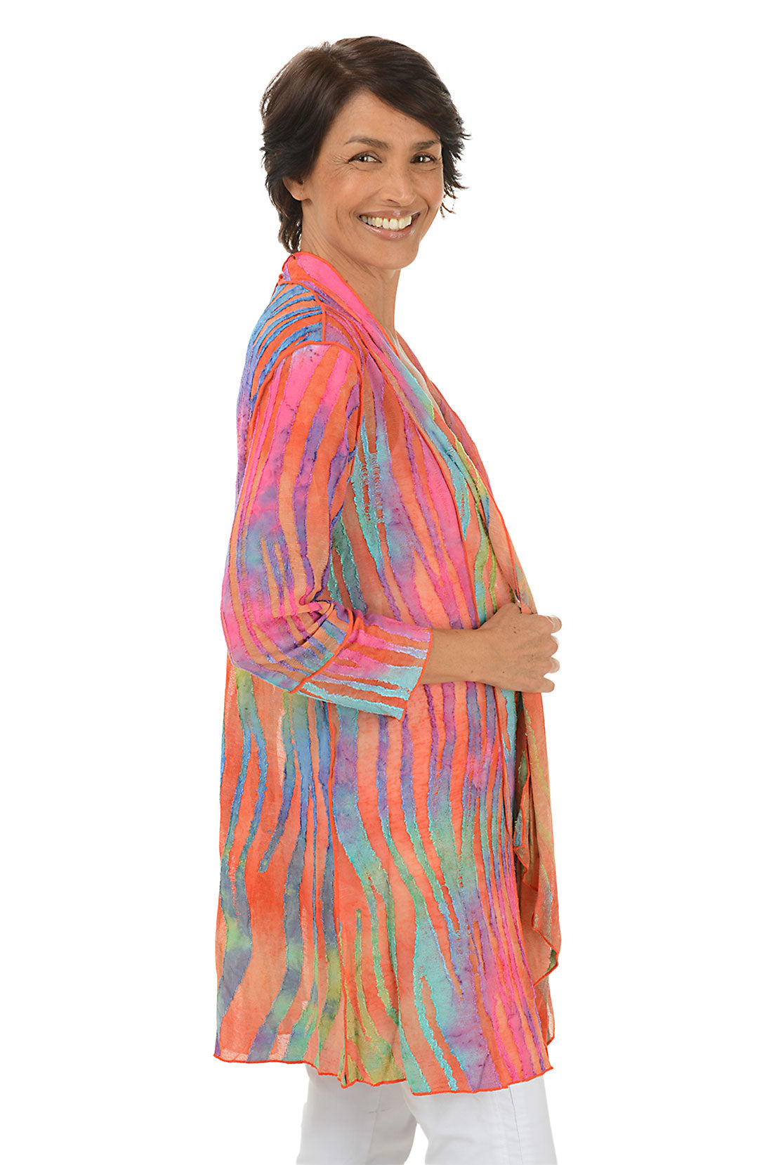 Woman wearing a colorful cardigan on a white background. Side shot.