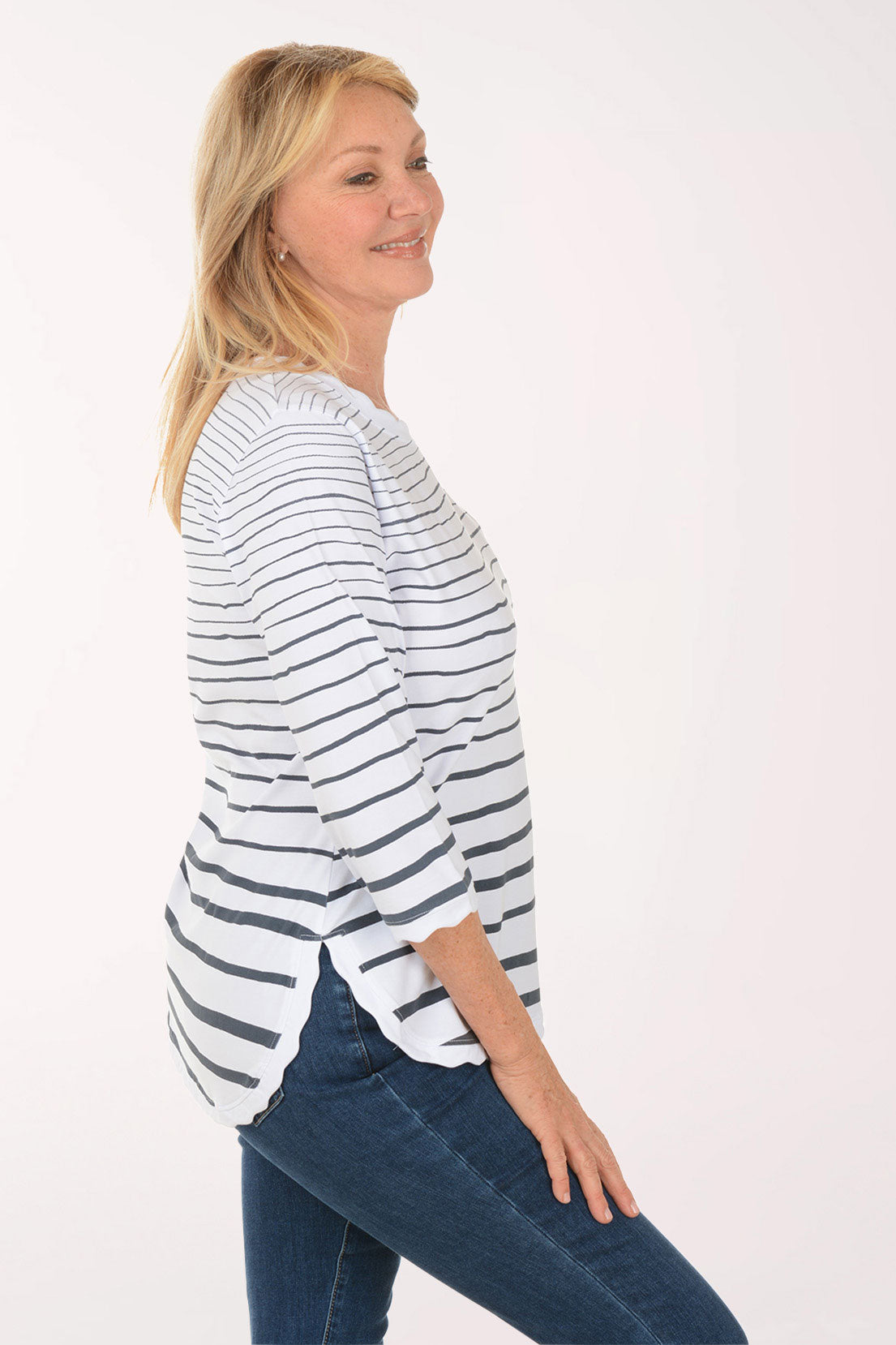 Woman wearing a striped shirt and jeans on a white background