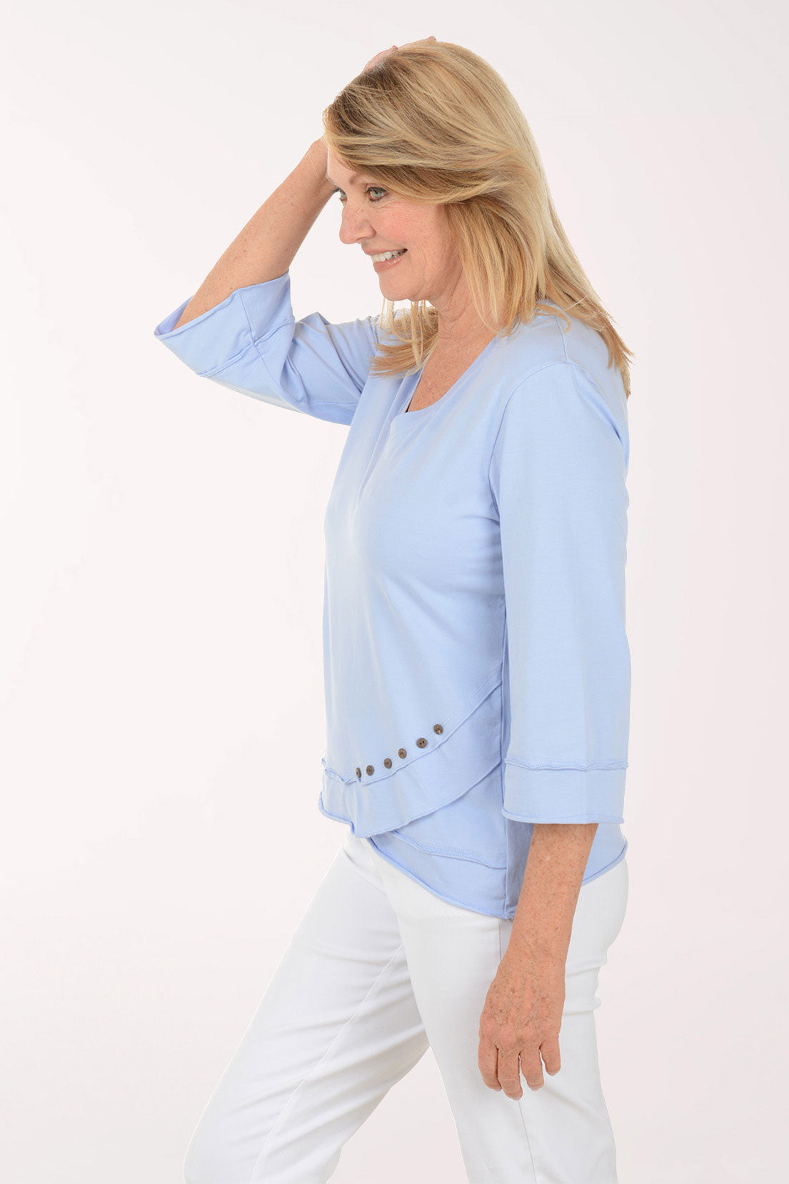 Woman wearing a light blue top with a white background