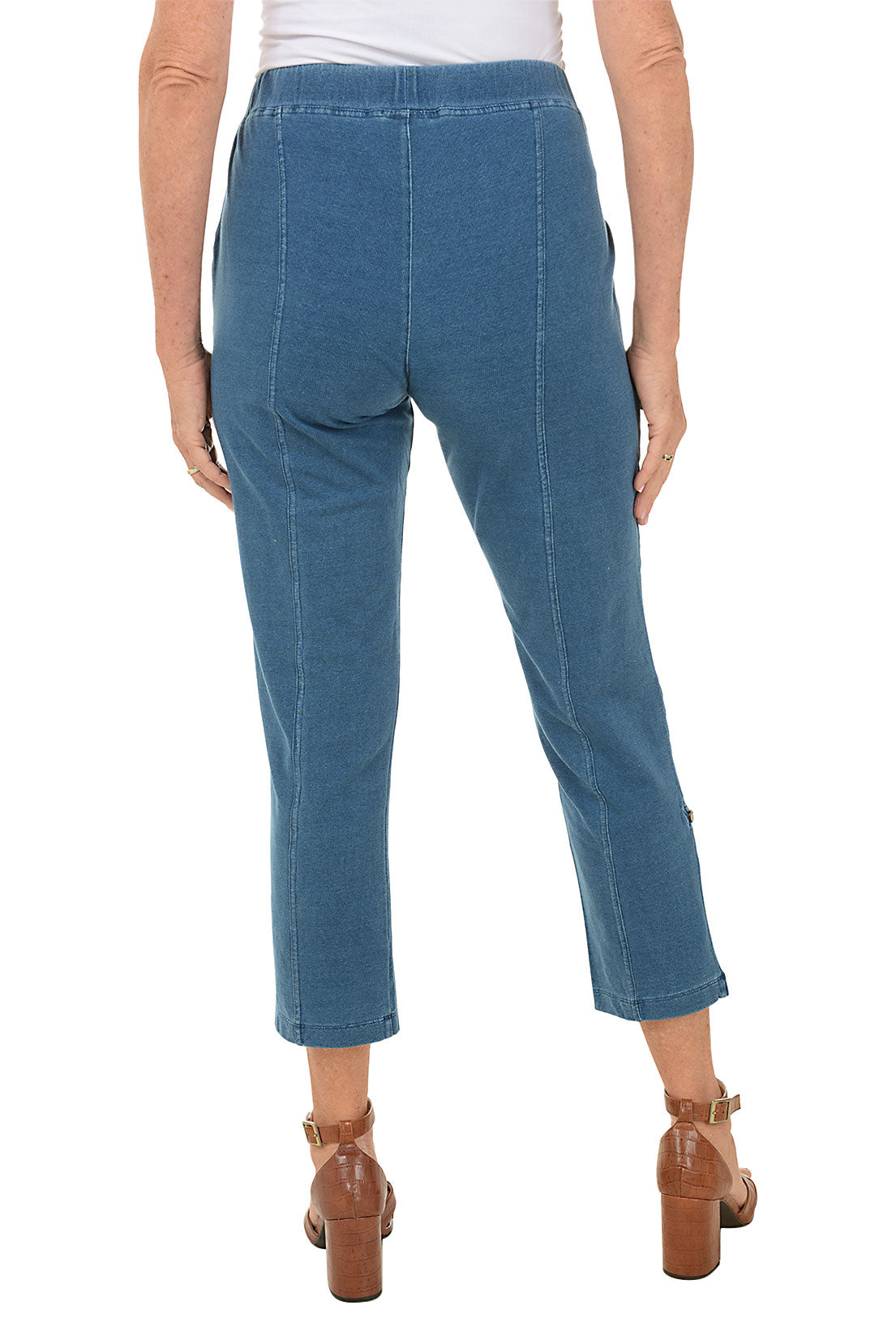 Blue jeans worn by a person on a white background. Back shot.