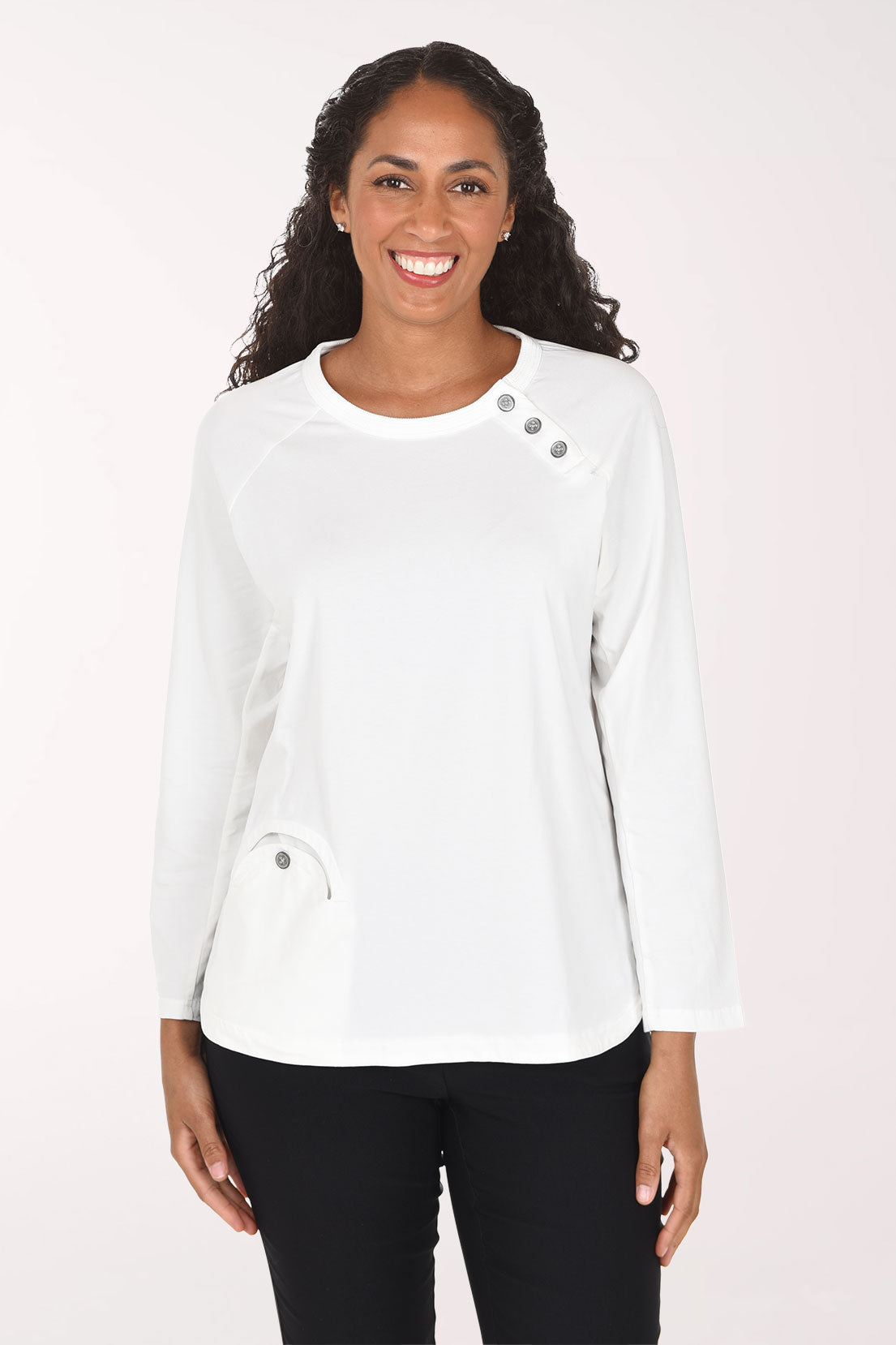 Woman wearing a white long sleeve top with three button embellishment