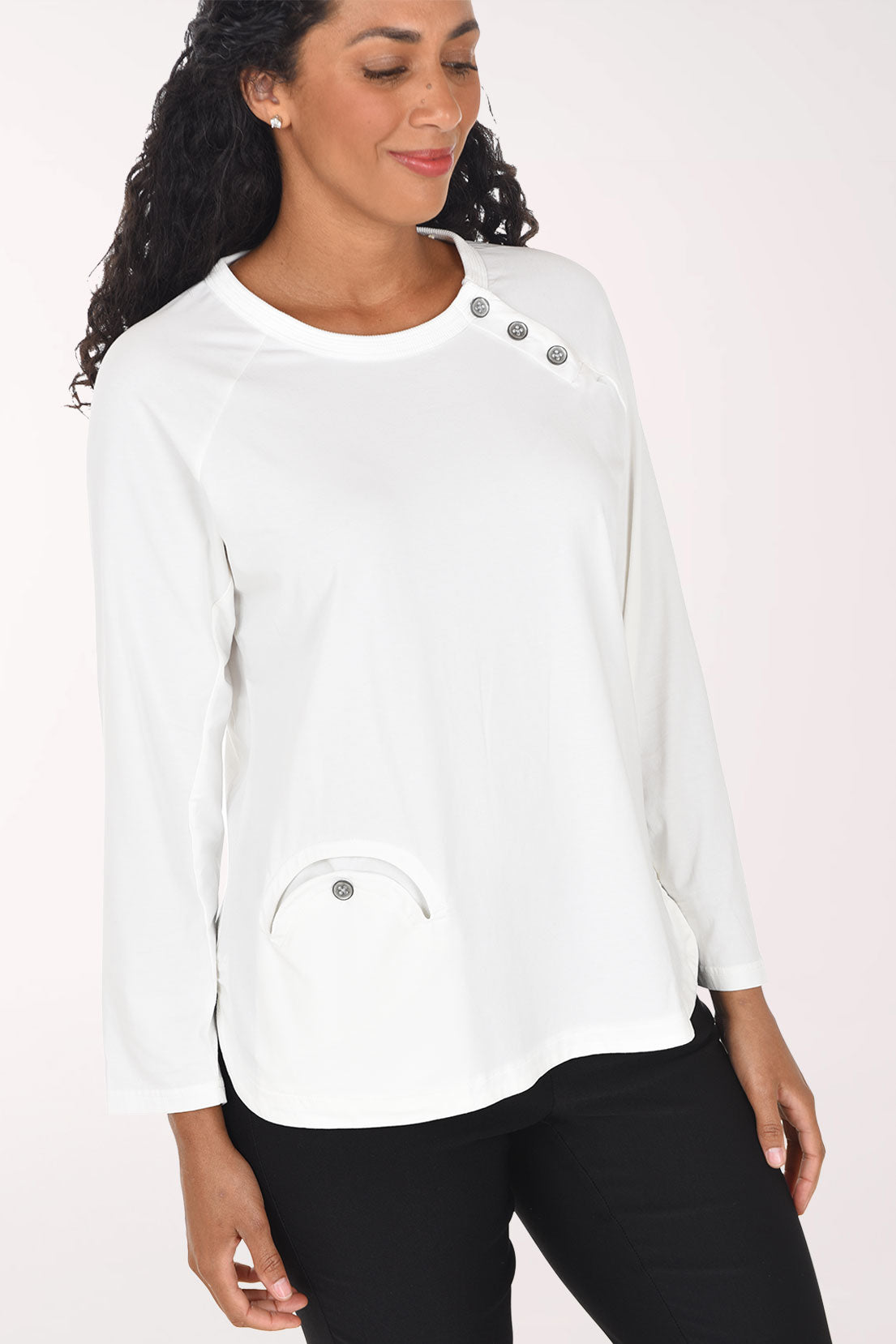 Woman wearing a white long sleeve top with three button embellishment