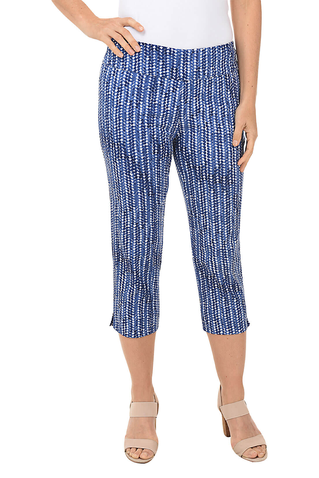 A front shot of a model wearing a pair of blue striped pull-on crop pants with an elastic waistband and a side slit on the hemline.