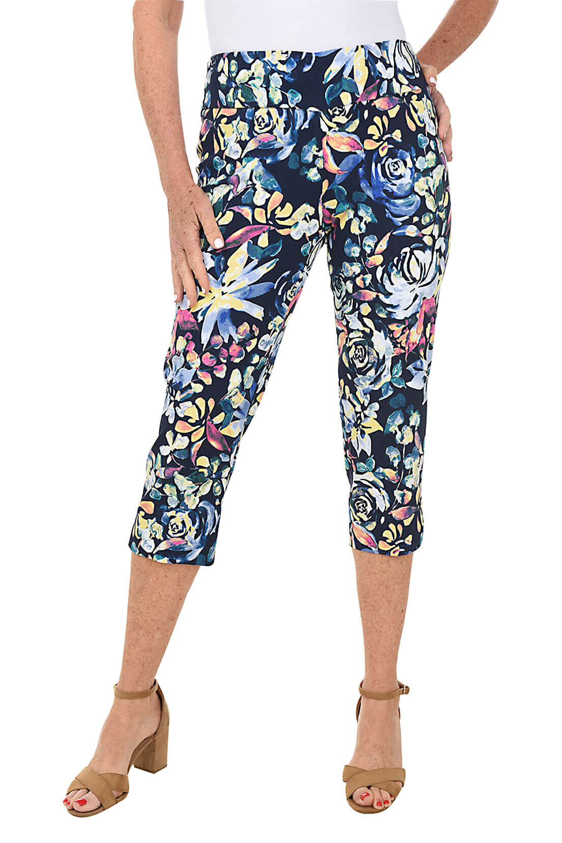 A front shot of a model wearing a pair of petite rose petal print pull-on crop pants with an elastic waistband and a side slit on the hemline.