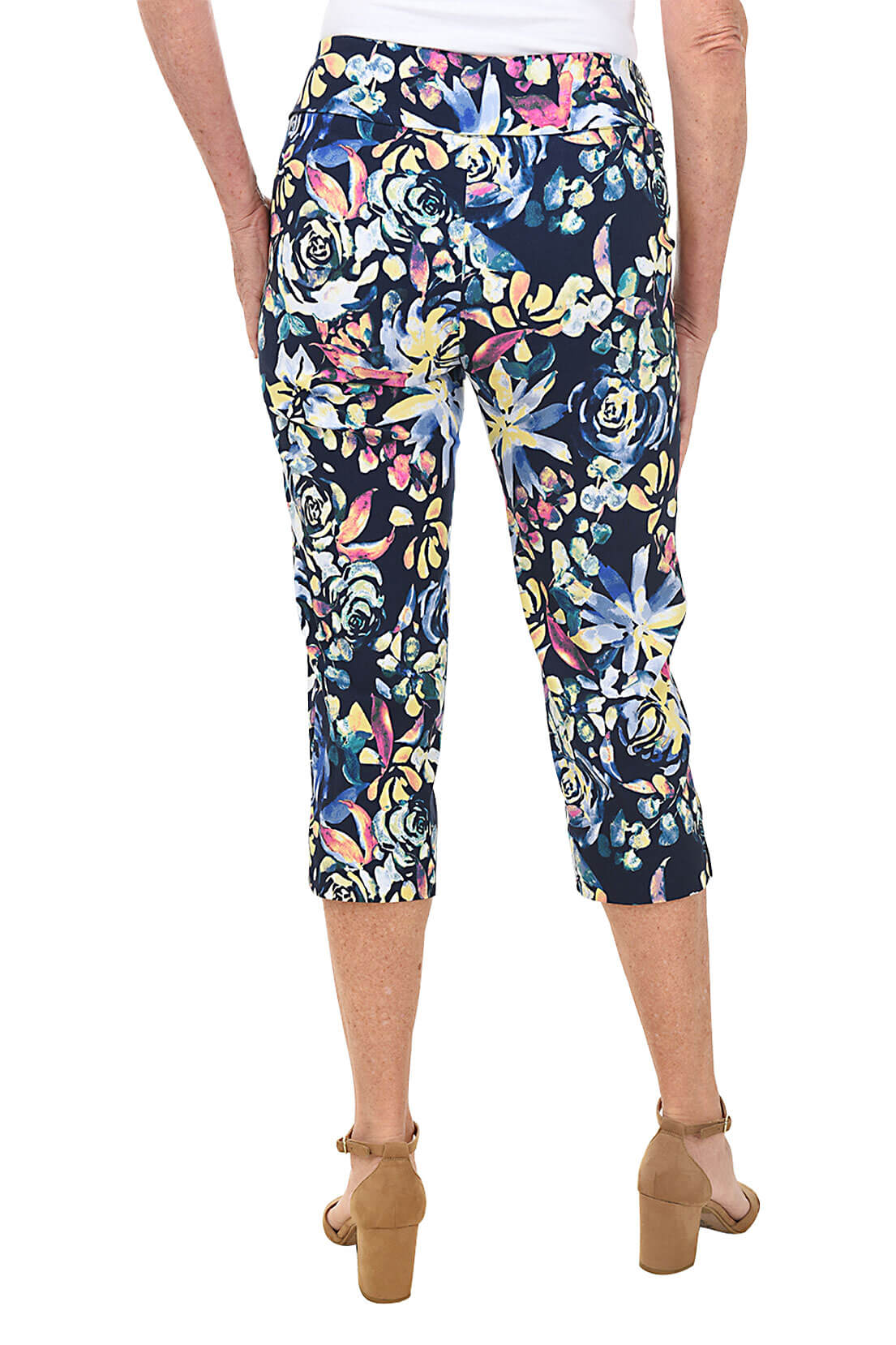 A back shot of a model wearing a pair of floral pull-on crop pants with an elastic waistband.