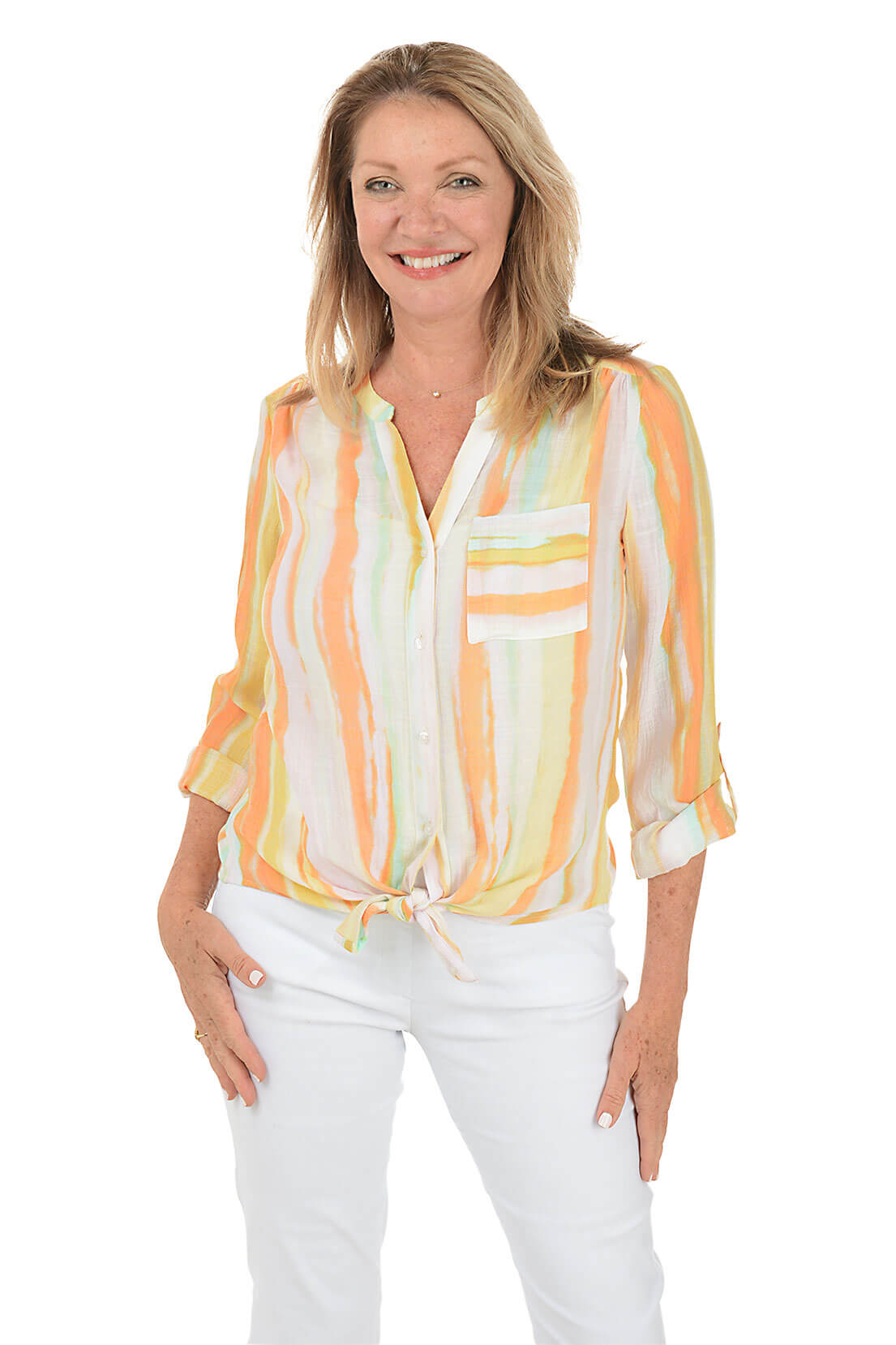 A front shot of a model wearing a striped button-front blouse with a mandarin collar and a left chest pocket, in shades of orange and white, paired with white pants.