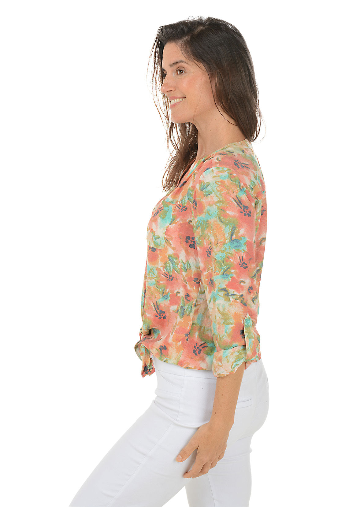 A side shot of a model wearing a floral button-front blouse with a mandarin collar and long sleeves, tied at the front, in a multi-color floral pattern.