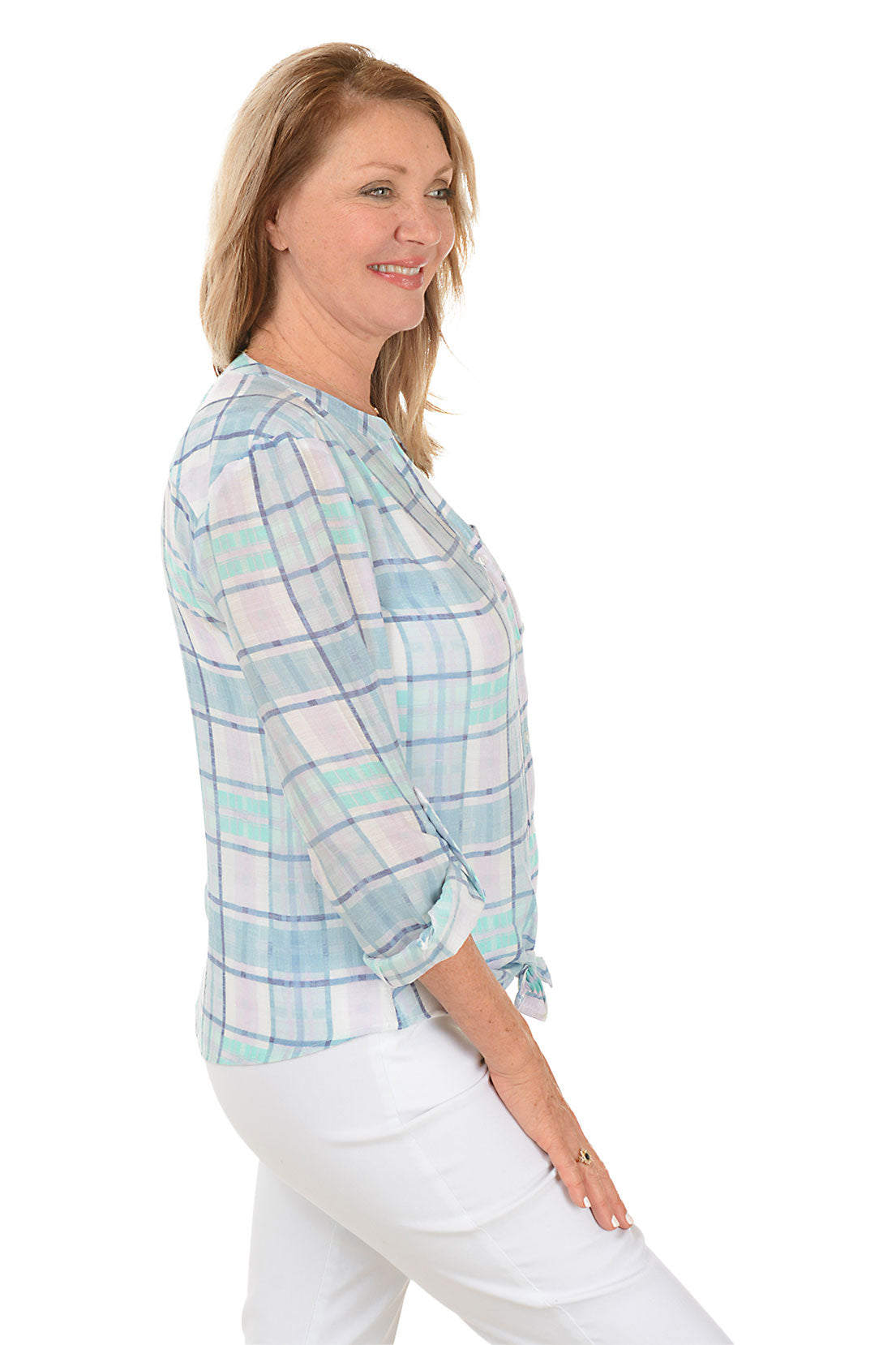 A side shot of a model wearing a blue and white plaid button-front blouse with a mandarin collar and long sleeves, paired with white pants.