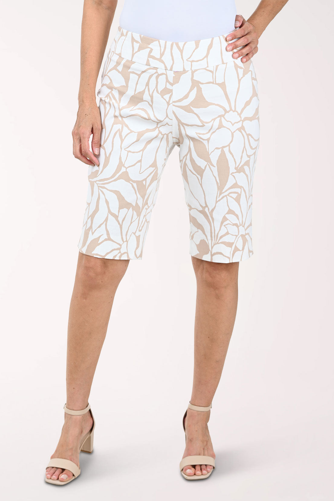 Person wearing white and beige floral patterned shorts on a white background