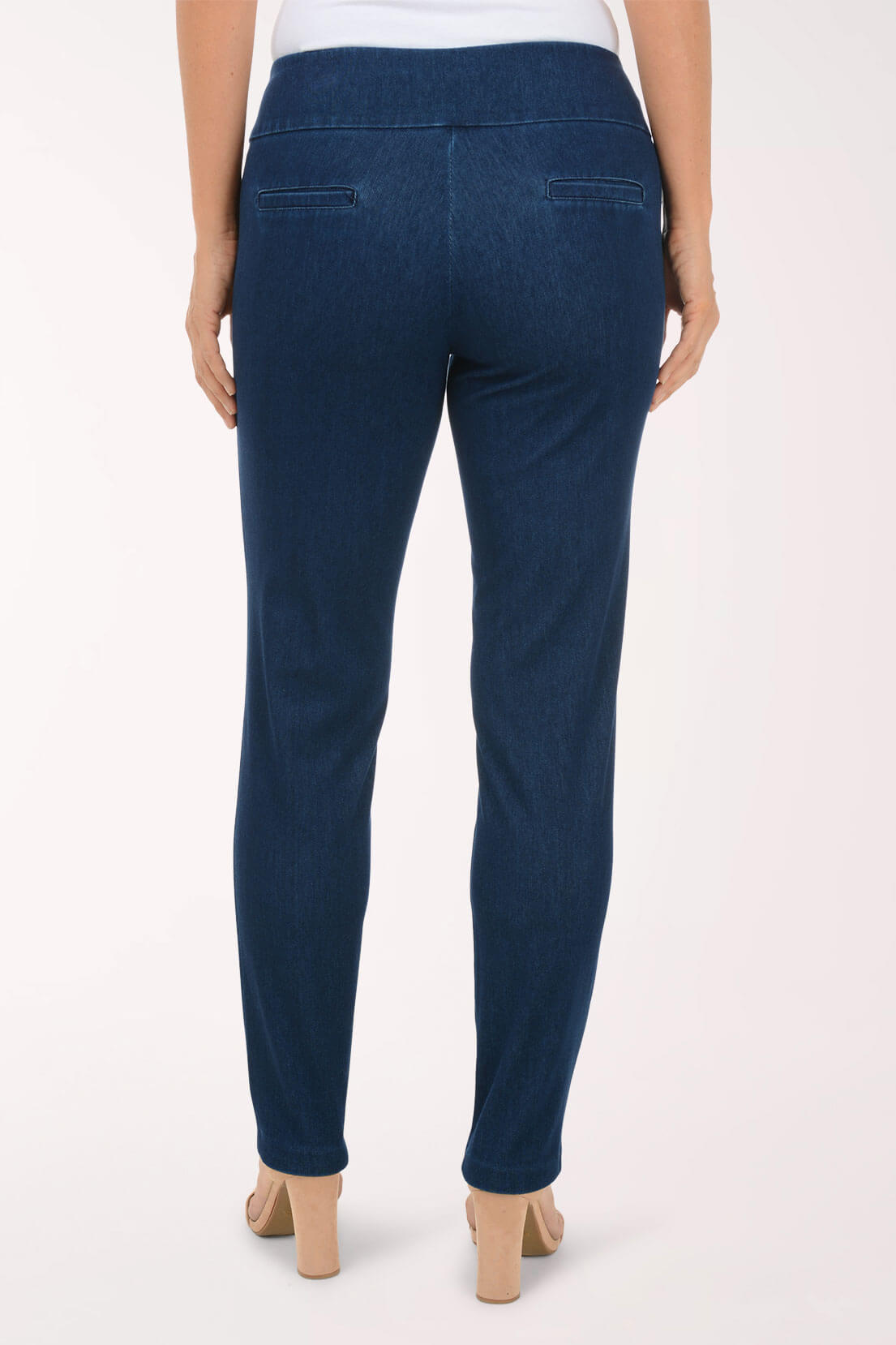 A back view of dark wash slim leg pull-on jeans showing the faux back slit pockets.