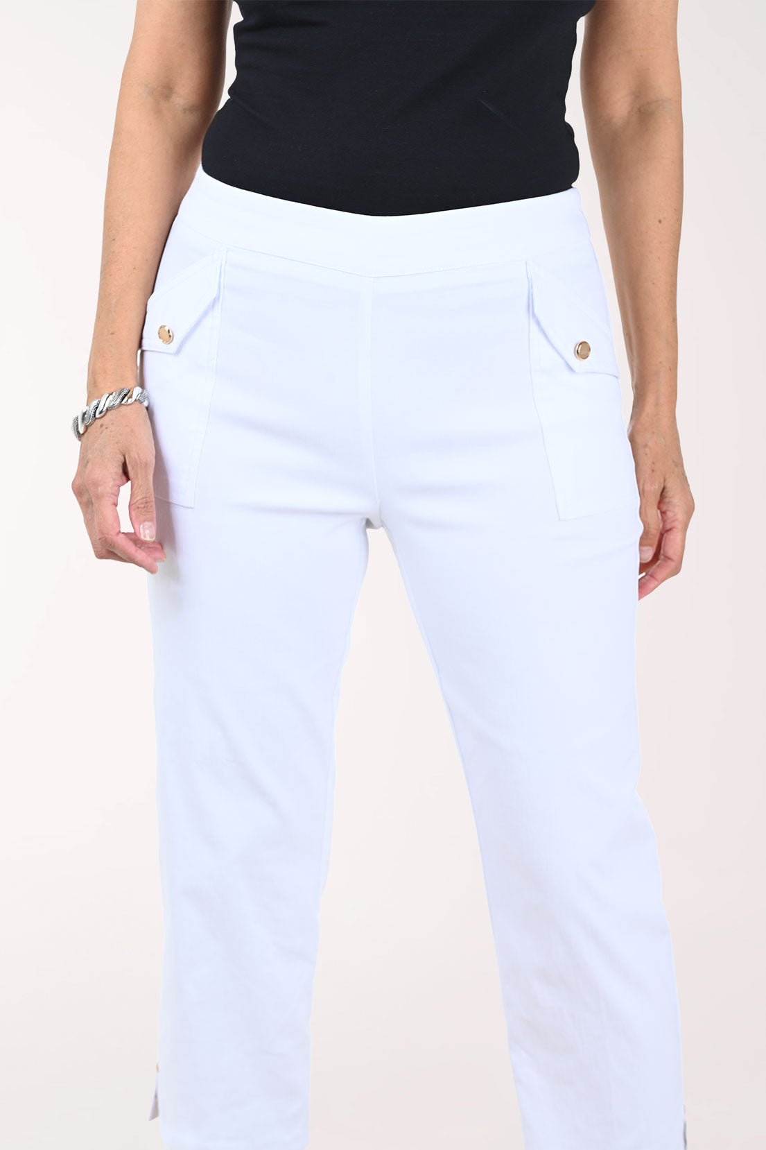 White capri pants worn by a person on a white background