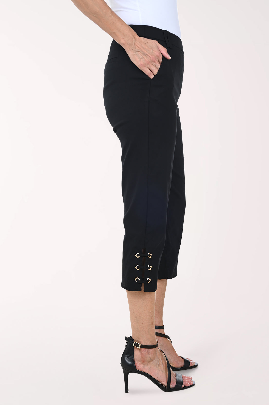 Black pants with lace-up sides worn by a person on a white background