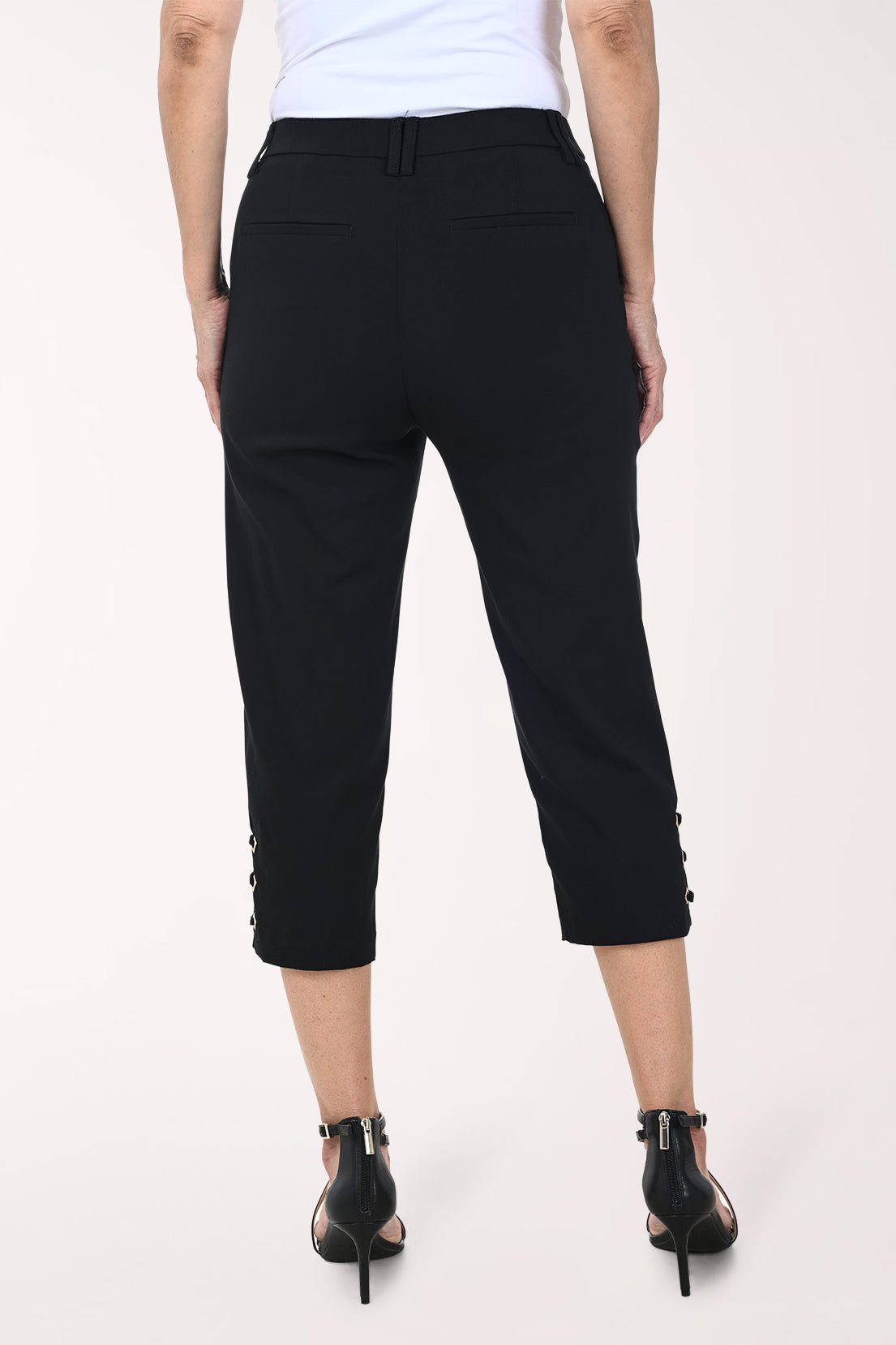 Black pants with lace-up sides worn by a person on a white background