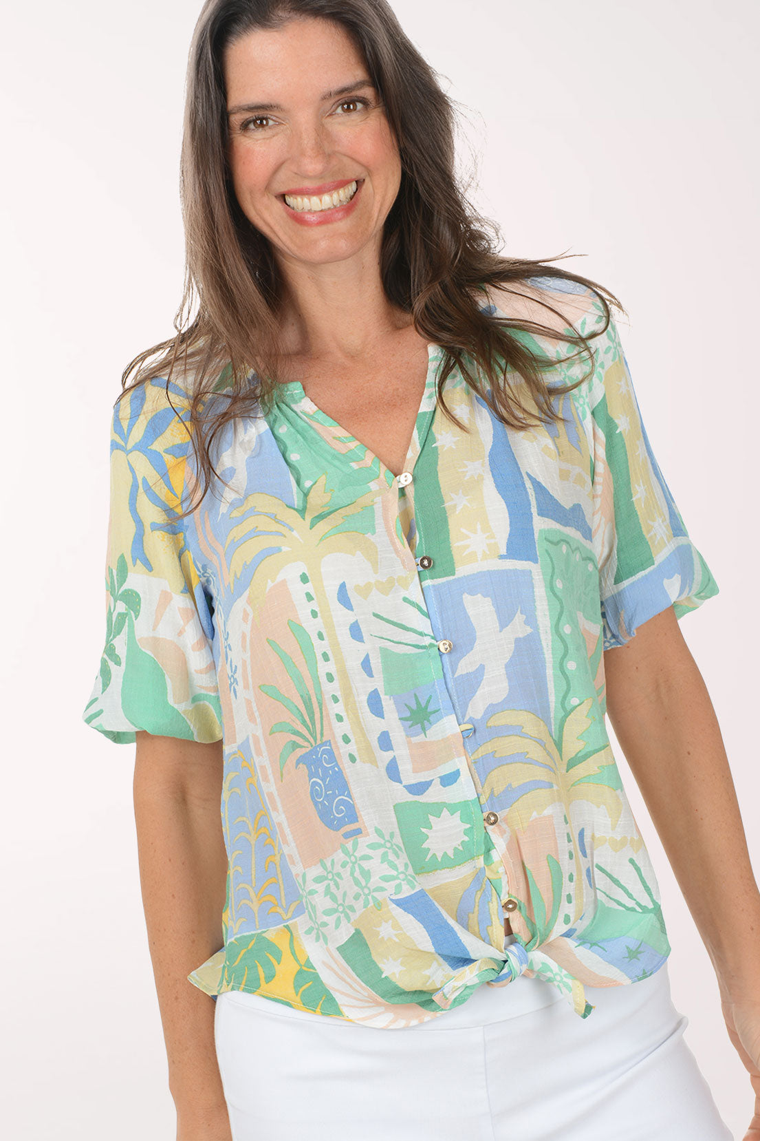 Woman wearing a colorful patterned blouse with a white background