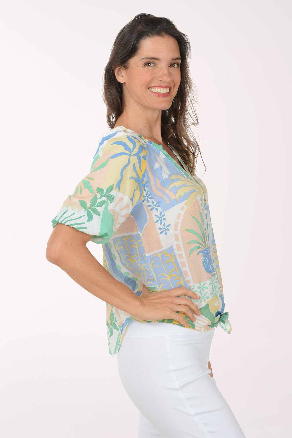 Woman wearing a colorful patterned blouse with a white background
