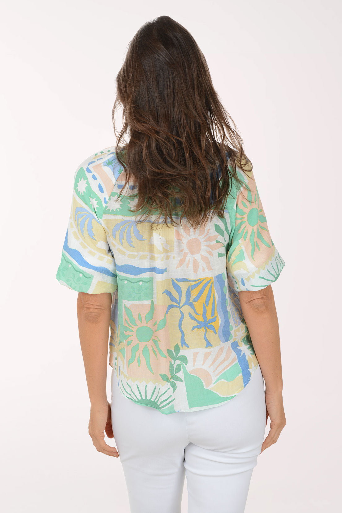 Woman wearing a colorful patterned blouse with a white background