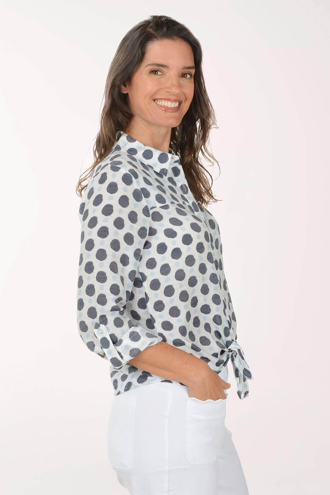 Woman wearing a polka dot blouse against a white background