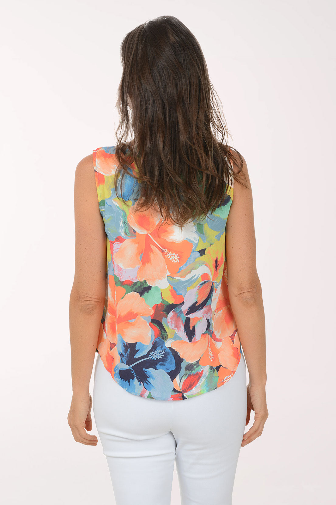 Woman wearing a colorful floral sleeveless top against a white background
