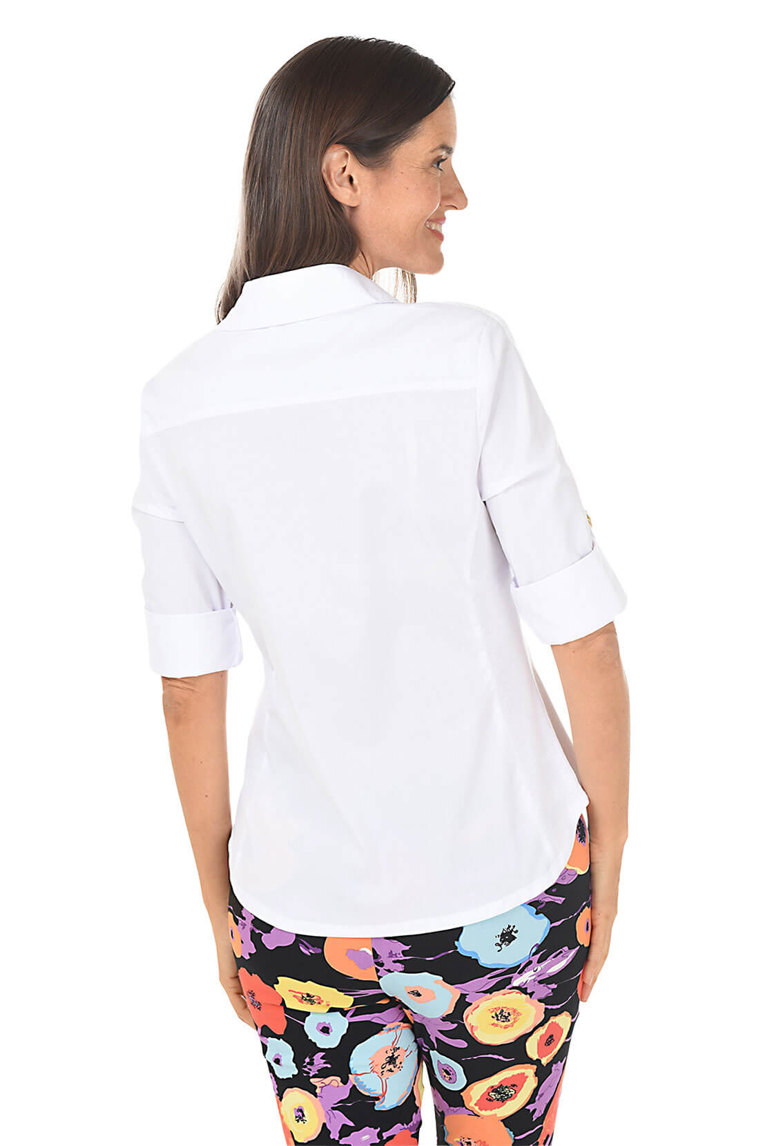 Woman wearing a white shirt and colorful floral pants on a white background. Back shot.