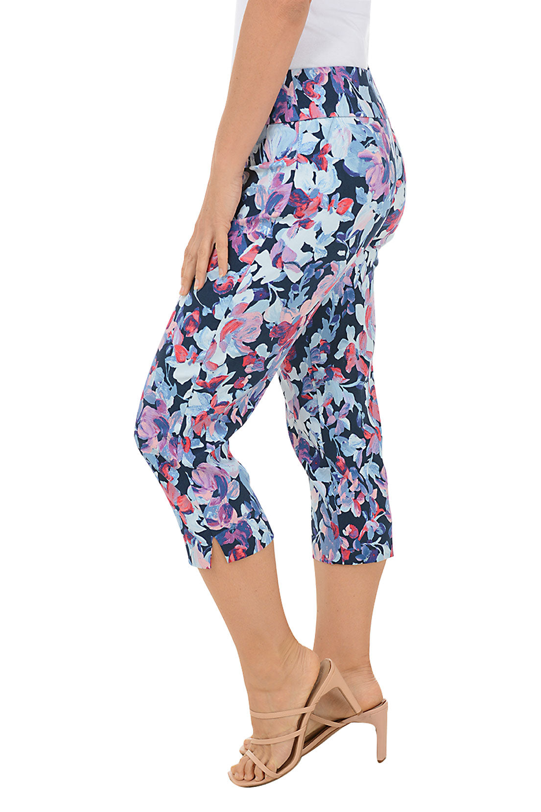 A side shot of a model wearing a pair of pull-on crop pants with a floral pattern, featuring a mid-rise waist and side slits.