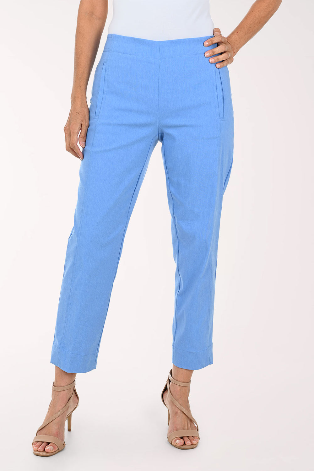 A model wearing light blue cropped trousers with side pockets, paired with beige strappy high-heeled sandals against a plain white studio background.