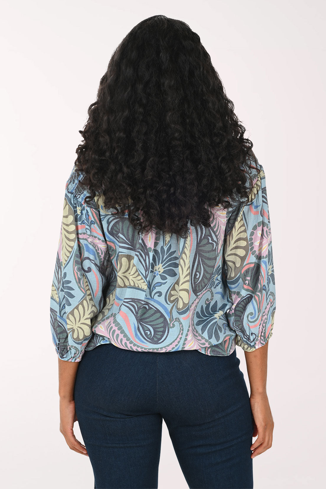 Woman wearing a patterned blouse with a white background