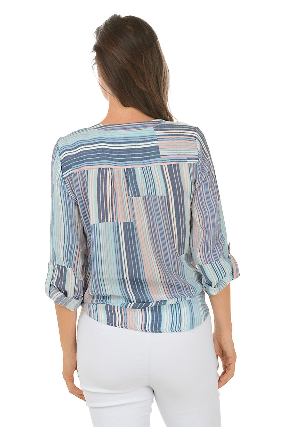 A back shot of a woman wearing a striped button-front blouse with a mandarin collar and long sleeves, tied at the front, paired with white pants.