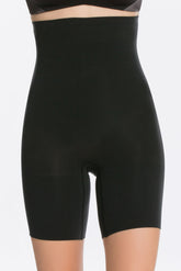 A front shot of a model wearing a pair of high-waisted black shapewear shorts with a seamless design.