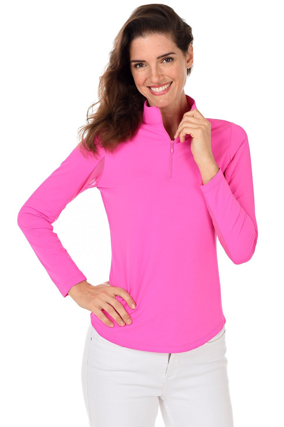 A woman smiling and wearing a long-sleeved hot pink sun shirt with a mock-neck collar and a pair of white pants.