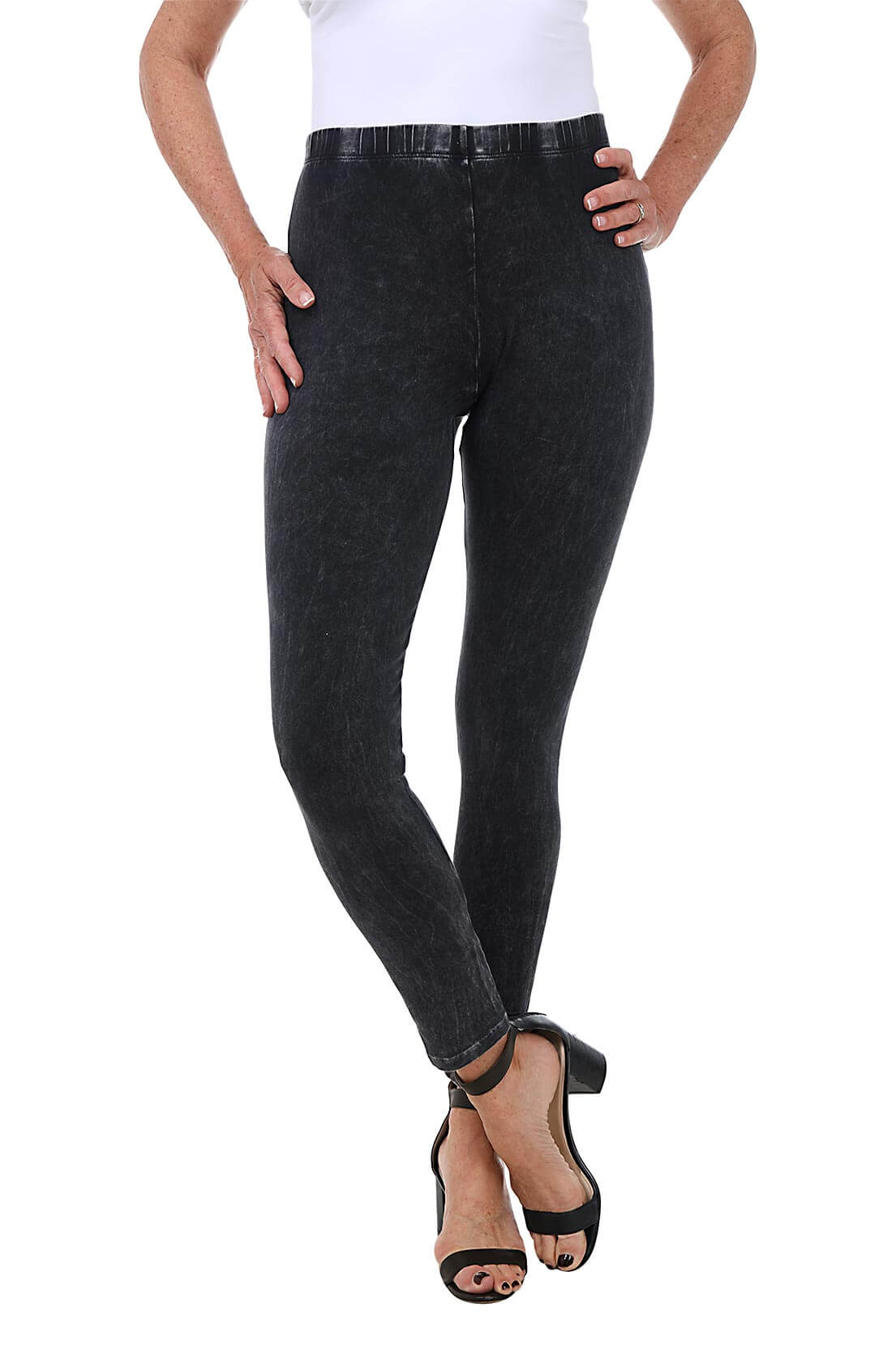 A front shot of a model wearing a pair of black mineral wash leggings with an elastic waistband, ankle-length design, and front rise positioned at 9 1/2 inches.