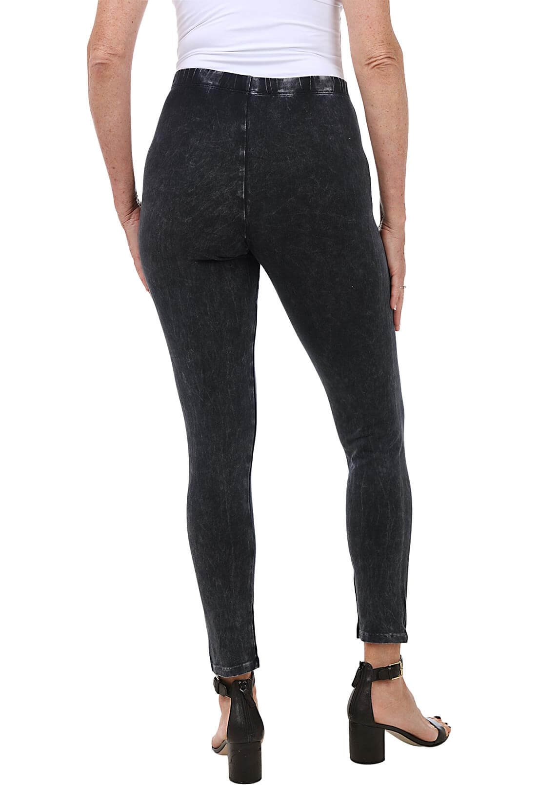 A back shot of a model wearing a pair of black mineral wash leggings with an elastic waistband, ankle-length design, and front rise positioned at 9 1/2 inches.