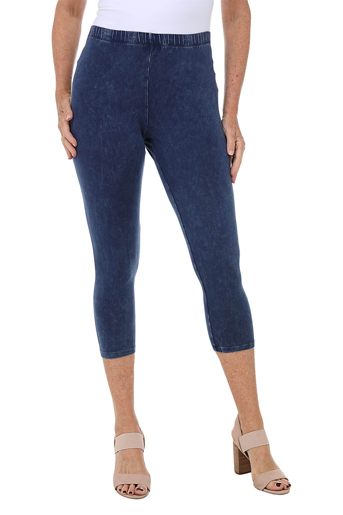 A front shot of a model wearing a pair of denim mineral wash capri leggings with an elastic waistband, made from stretchy cotton fabric.