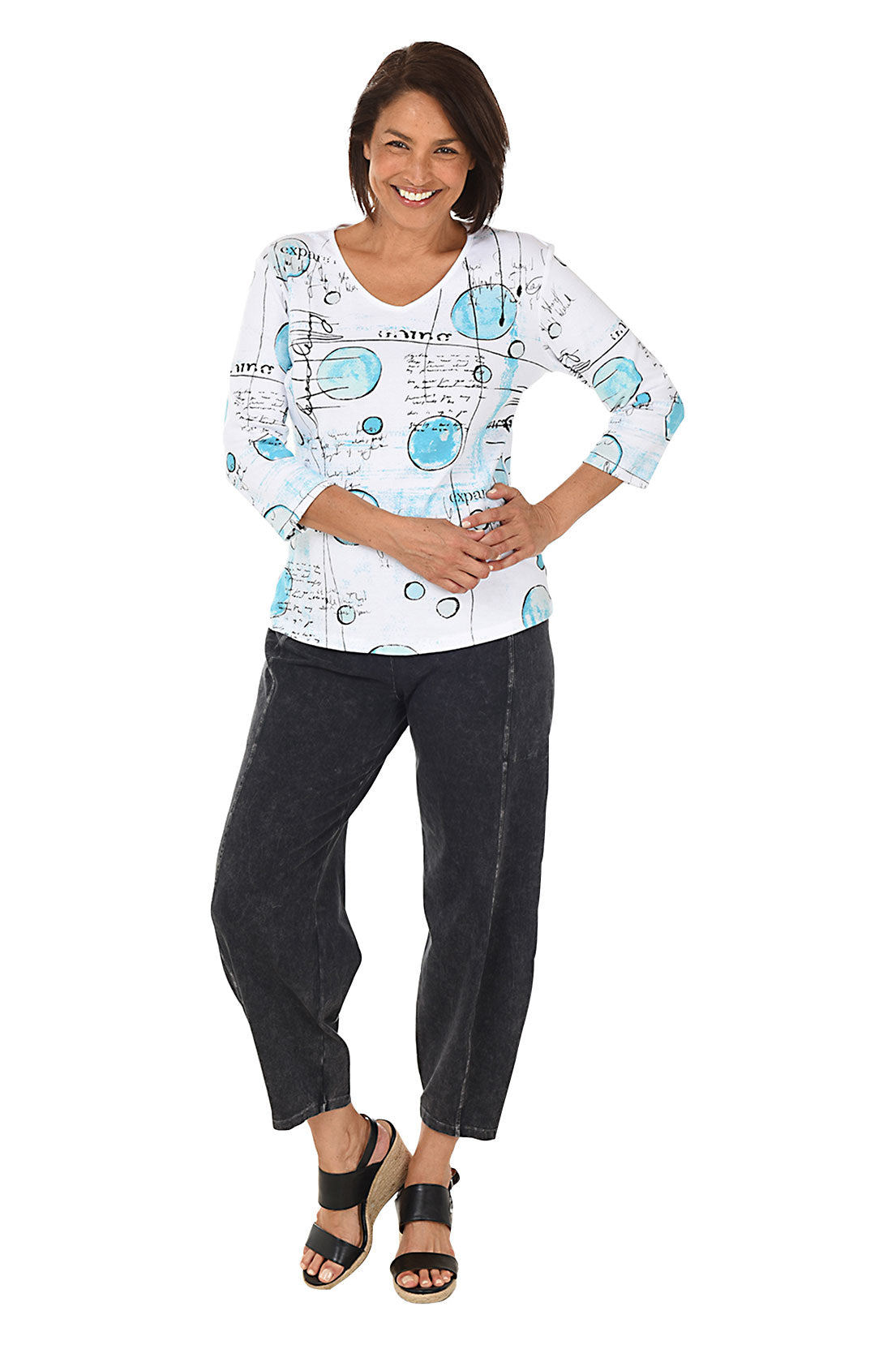 A full length shot of a model wearing a black mineral wash pull-on ankle pants with an elasticized waistband, dual side pockets, and tapered leg design.