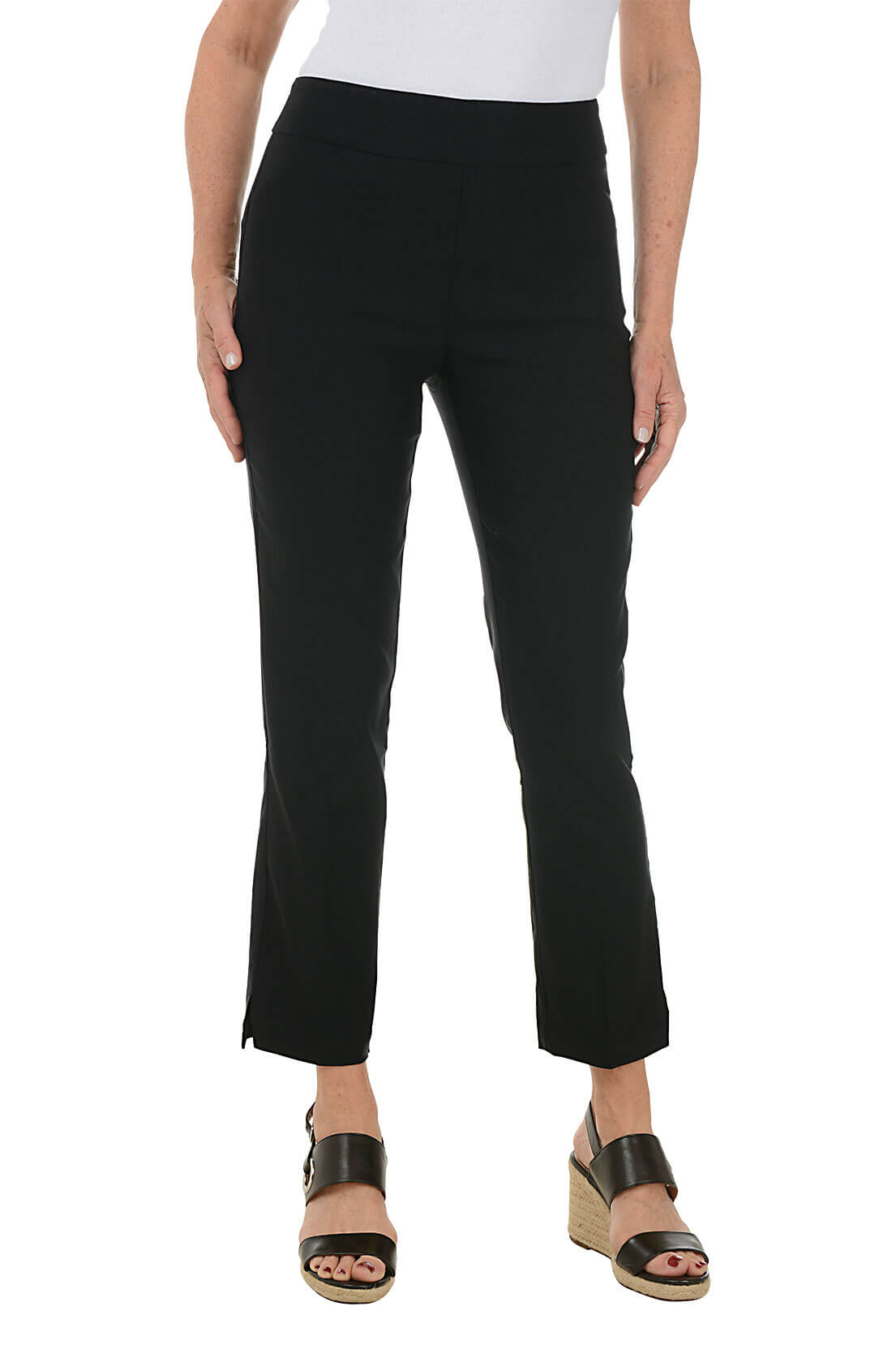 A front shot of a model wearing a pair of black ankle pants with an elastic waistband, dual front pockets, and side slits on the hemline. The pants are pull-on style with no visible zipper.