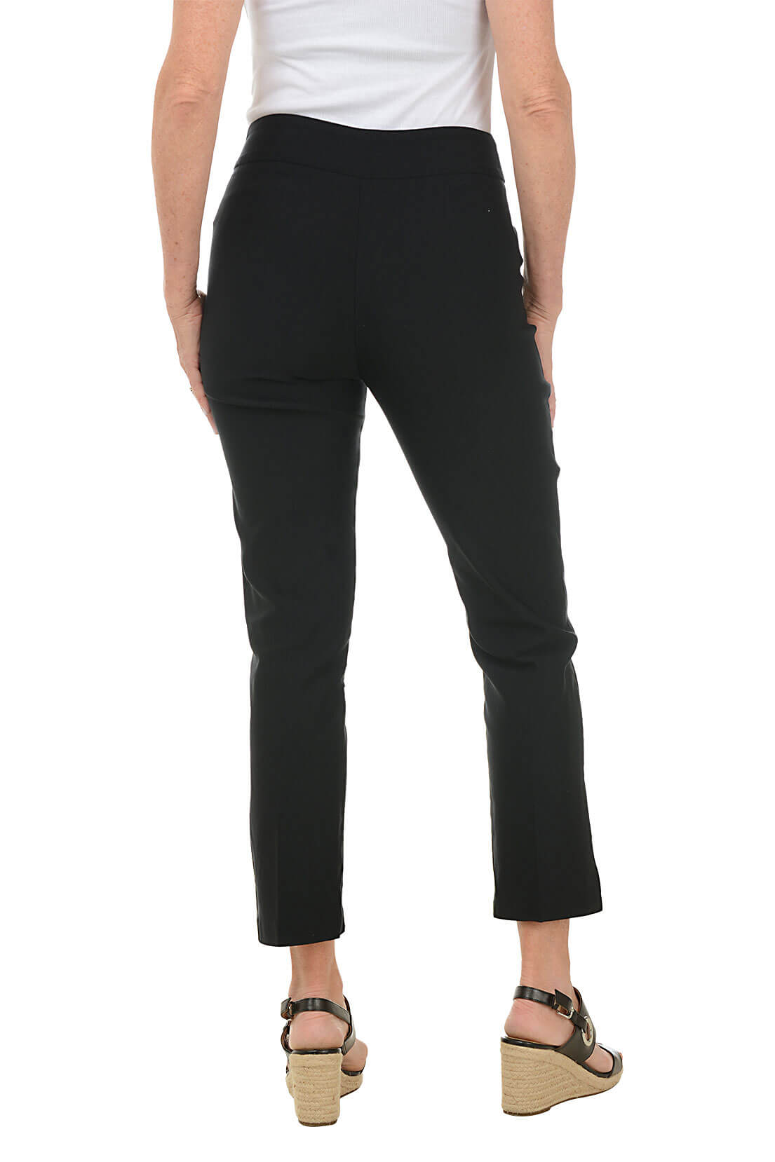 A back shot of a model wearing a pair of black ankle pants with an elastic waistband, dual front pockets, and side slits on the hemline. The pants are pull-on style with no visible zipper.