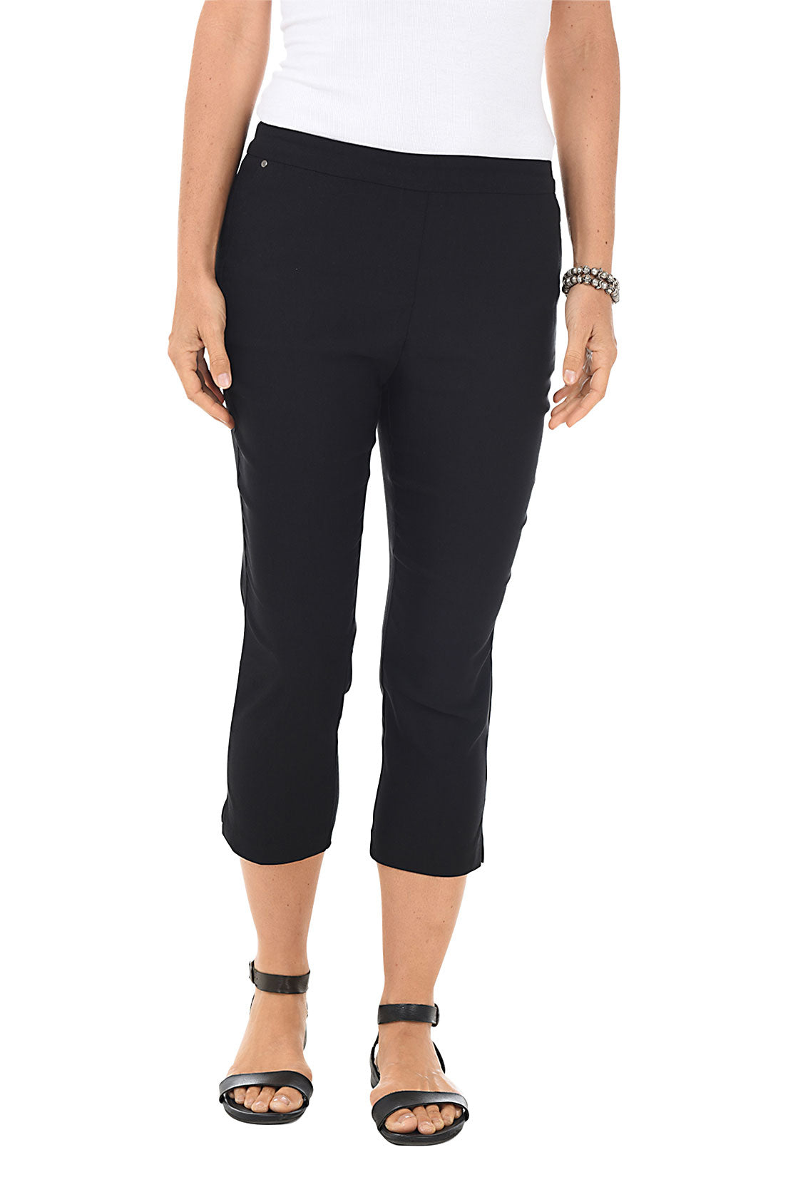 A front shot of a model wearing black pull-on capri pants with an elastic waistband and side slits at the hemline, paired with a white top and black sandals.